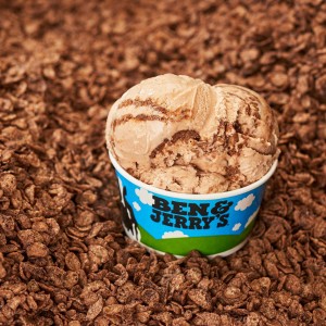A cup of Ben and Jerry's ice cream sitting on a bed of chocolate cereal.